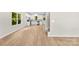 Bright, open living room showcasing hardwood floors, white cabinets, stairs, and ample sunlight filtering through large windows at 1411 Duhart Ave, Gastonia, NC 28054