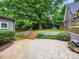 Multi-tiered backyard with a patio, lush lawn, brick stairs, and mature trees at 1425 Downs Ave, Charlotte, NC 28205