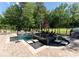 The in-ground pool features in-pool seating and spa with mature trees providing a private setting at 143 Jeremy Point Pl, Mooresville, NC 28117