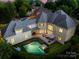 Backyard aerial view featuring a pool, a hot tub, manicured green lawn, and an outdoor living space at 15038 Jockeys Ridge Dr, Charlotte, NC 28277