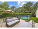 Well-manicured backyard with comfortable seating, an umbrella, and a fenced-in pool area at 15038 Jockeys Ridge Dr, Charlotte, NC 28277