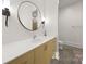 Bathroom featuring a modern vanity, sink, and circular mirror, complemented by sconce lighting at 15038 Jockeys Ridge Dr, Charlotte, NC 28277
