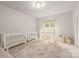 Bedroom featuring two cribs, a cozy play tent, and a soft rug at 15038 Jockeys Ridge Dr, Charlotte, NC 28277