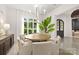 Bright dining room featuring a round wooden table, upholstered chairs, a sideboard, and a modern chandelier at 15038 Jockeys Ridge Dr, Charlotte, NC 28277