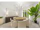 Bright dining room featuring a round wooden table, upholstered chairs, large window, and modern chandelier at 15038 Jockeys Ridge Dr, Charlotte, NC 28277