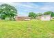 Expansive backyard showcasing a well-maintained lawn, mature trees, and a detached storage shed at 1690 Montevista Dr, Shelby, NC 28150