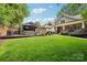 A backyard featuring a covered patio and outdoor seating, with a lush green lawn leading up to the house at 1701 Dearmon Dr, Charlotte, NC 28205
