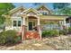 Charming home with a inviting brick staircase leading to a cozy covered porch with hanging flower baskets at 1701 Dearmon Dr, Charlotte, NC 28205