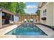 Inviting backyard pool featuring lounge chairs, privacy fence and lush landscaping at 1701 Dearmon Dr, Charlotte, NC 28205