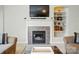 Cozy fireplace with tiled surround, adjacent to a built-in bookshelf, creating a focal point in the living area at 17130 Bridgeton Ln, Huntersville, NC 28078
