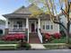 Charming home featuring a red door, beautiful landscaping with pink flowers, and a welcoming front porch at 17130 Bridgeton Ln, Huntersville, NC 28078