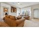 Bright living room with large windows, neutral carpet, and comfortable seating, perfect for relaxation and entertaining at 17130 Bridgeton Ln, Huntersville, NC 28078