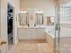 Bright primary bathroom with dual sinks, soaking tub, a glass shower, and plenty of storage space at 17130 Bridgeton Ln, Huntersville, NC 28078