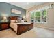 Serene primary bedroom features a large window, a neutral color scheme, and carpeted floors at 17130 Bridgeton Ln, Huntersville, NC 28078