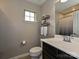 Well-lit bathroom featuring a modern vanity, decorative shelves, and neutral-toned walls at 1769 Evergreen Dr, Charlotte, NC 28208