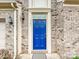 Close-up of the attractive blue front door of the home, accented by brick and elegant exterior lighting at 1769 Evergreen Dr, Charlotte, NC 28208