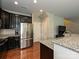Functional kitchen featuring dark cabinetry, stainless steel refrigerator, and a breakfast bar area at 1769 Evergreen Dr, Charlotte, NC 28208