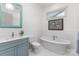 Inviting bathroom features a soaking tub, blue vanity, and stylish fixtures at 19031 Brandon James Dr, Cornelius, NC 28031