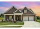 Charming home with a two-car garage, manicured lawn, rocking chairs, and inviting curb appeal at 19031 Brandon James Dr, Cornelius, NC 28031