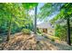 Lush backyard with mature trees and landscaping surrounding the home's exterior, offering privacy at 204 Aztec Cir, Mooresville, NC 28117