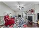 Bright living room with hardwood floors, a ceiling fan, a gray sofa, and fireplace creates an inviting atmosphere at 204 Aztec Cir, Mooresville, NC 28117