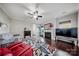Spacious living room with hardwood flooring, a ceiling fan, fireplace, and ample natural light, perfect for relaxation at 204 Aztec Cir, Mooresville, NC 28117