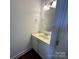 Bright powder room featuring a stylish, round mirror and single sink vanity with white cabinets at 204 Aztec Cir, Mooresville, NC 28117