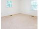 This bright bedroom features neutral carpet and two windows, creating a serene and inviting space at 2222 Hearthstone Dr, Gastonia, NC 28056