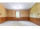 Inviting dining room with wood-paneled walls, natural light from a window, and a simple chandelier at 2222 Hearthstone Dr, Gastonia, NC 28056