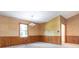 Cozy dining room featuring wood-paneled walls, a classic chandelier, and a bright window at 2222 Hearthstone Dr, Gastonia, NC 28056