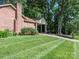This home features a brick exterior, manicured lawn, and a covered side patio at 2222 Hearthstone Dr, Gastonia, NC 28056