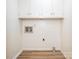 Bright laundry room with overhead storage, wood-look flooring, and washer/dryer hookups at 2222 Hearthstone Dr, Gastonia, NC 28056