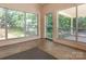 Bright sunroom featuring large windows with views of the surrounding yard and mature trees at 2222 Hearthstone Dr, Gastonia, NC 28056