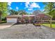 Rear view of a brick home featuring a driveway, garage, and lawn at 245 Kingsway Cir, Charlotte, NC 28214