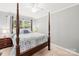 Bedroom with four-poster bed, carpet, and large windows at 245 Kingsway Cir, Charlotte, NC 28214
