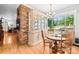 Bright dining room with hardwood floors, classic china cabinet, round wooden table, and sunny backyard views at 245 Kingsway Cir, Charlotte, NC 28214