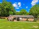 Charming brick home featuring a lush front lawn, manicured landscaping, and mature trees, offering great curb appeal at 245 Kingsway Cir, Charlotte, NC 28214