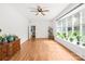 Sunlit living room featuring hardwood floors, a ceiling fan, and large bay window with plants at 245 Kingsway Cir, Charlotte, NC 28214