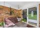 Cozy brick porch featuring a swing, brick wall, and tile flooring with a welcoming entrance at 245 Kingsway Cir, Charlotte, NC 28214