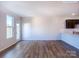 Bright room with hardwood floors, white walls, and a door and window letting in natural light, adjacent to the kitchen area at 2535 Ruby Dixon Crossing Dr # 19, Gastonia, NC 28056
