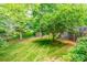 A lush backyard with green grass, mature trees, landscaping, and a wooden deck at 2730 Tiffany Dr, Rock Hill, SC 29732