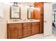 Bathroom featuring dual sinks, granite counters, wood cabinetry, and a linen closet at 2730 Tiffany Dr, Rock Hill, SC 29732