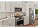 Bright kitchen featuring stainless steel appliances, white cabinets, and quartz countertops at 3009 Loso Ter # 58, Charlotte, NC 28217