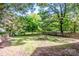 Spacious backyard featuring a large grassy area, a fire pit, a fence, and mature trees at 310 Patterson Ave, Mooresville, NC 28115