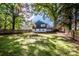Spacious backyard featuring a large grassy area, a fire pit, a fence, and mature trees at 310 Patterson Ave, Mooresville, NC 28115