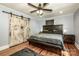Bedroom with light blue walls, wood floors, ceiling fan, and decorative barn doors at 310 Patterson Ave, Mooresville, NC 28115