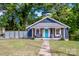 Bungalow-style home with inviting front porch and charming curb appeal surrounded by lush greenery at 310 Patterson Ave, Mooresville, NC 28115