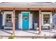 Inviting front porch featuring comfortable seating and a vibrant turquoise door with decorative wreath at 310 Patterson Ave, Mooresville, NC 28115