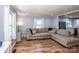 Cozy living room featuring hardwood floors, a comfortable sofa, and a seamless flow into the kitchen area at 310 Patterson Ave, Mooresville, NC 28115