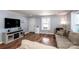 Comfortable living room with hardwood floors, a plush sofa, and ample natural light from the windows at 310 Patterson Ave, Mooresville, NC 28115